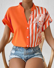 Blus i panel med blommönster med knapp och kort ärm