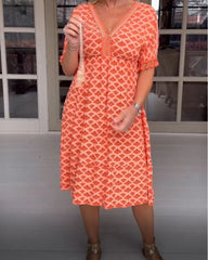 V-ringad klänning med tryck och fransar