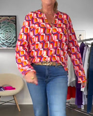 Blus med kontrasterande färger och geometriska mönster